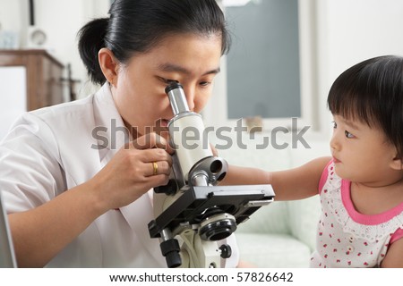 Little Chinese girl trying to distract her mom concentration from working on microscope