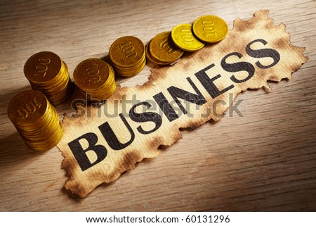 Business written on vintage paper and stack of gold coins and gold rocks