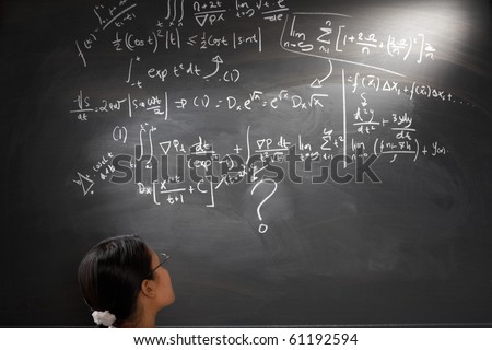 Looking at difficult complex mathematics equation on balckboard