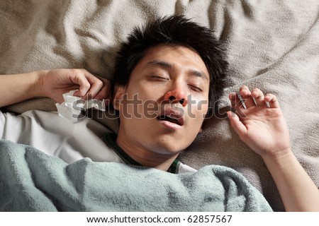 A male Chinese man is sleeping while catching cold and breathing through mouth because of the flu
