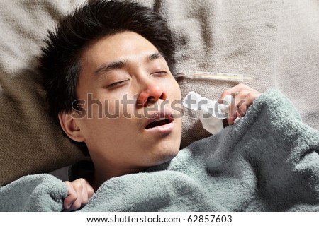 An Asian sick man, sleeping with thermometer showing high temperature