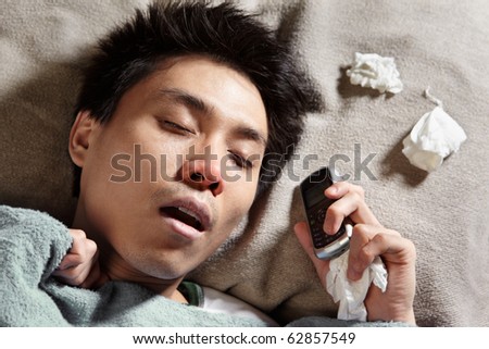 A sick man sleeping while holding his cell phone