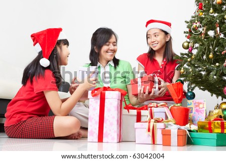 Mother and daughters exchanging present on Christmas