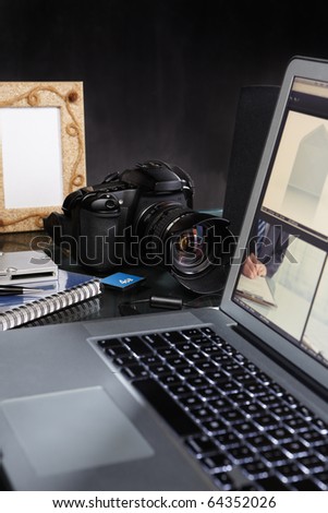 Photographer desk with laptop, DSLR camera and all other stuffs around