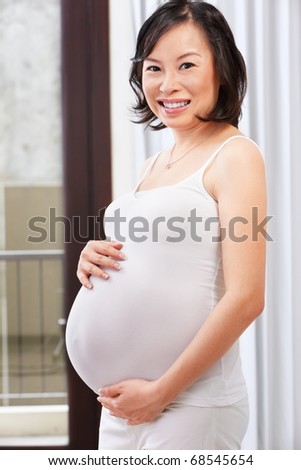 Chinese pregnant lady caress her big stomach