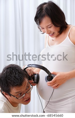 Chinese couple stimulating the fetus using music with headset