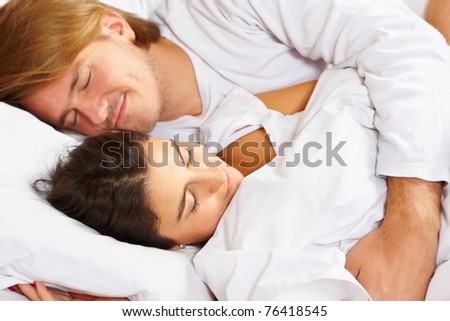 Happy couple showing their romance on fully covered white bed