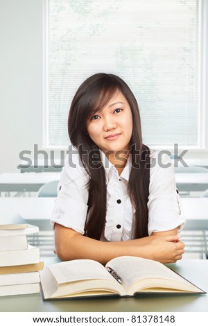 Beautiful Chinese female student posing to camera in classroom