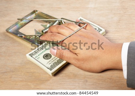 People hand trapped while catching the money placed on the mousetrap
