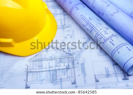 Architect design printout in bluish color with yellow safety helmet