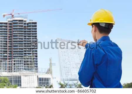 Male contractor or civil engineer looking at the building project on progress