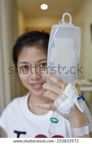Patient Hold her IV drip tube to go to toilet. Focus on the hand holding the IV tube