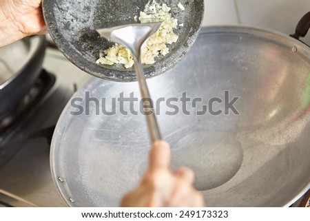 Stir frying the crushed garlic on the wok