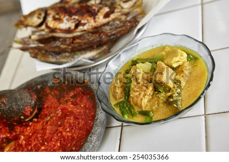 Indonesian local meal consisting sayur lodeh / vegetables with coconut milk soup and fried fish plus sambal / chili paste from Indonesia