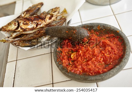 Sambal, special spicy chili paste in Indonesia, making on stone mortar to be eaten with another meal like fried fish