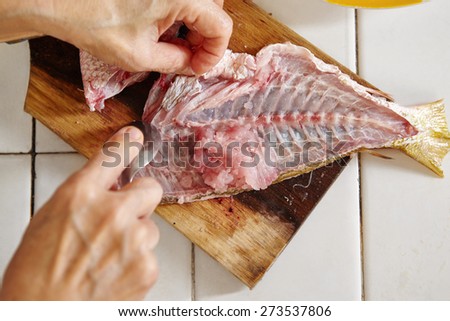Raw fish being peeled and and meat taken to make fish cake