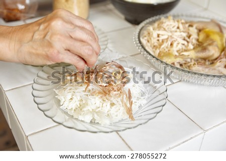 Food preparation for soto, the traditional Indonesian chicken soup. a plate with steamed rice and rice vermicelli and shredded chicken