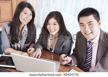 Group of Chinese business people smiling to camera in the office