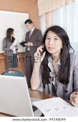 Chinese businesswoman talking on cell phone in the office
