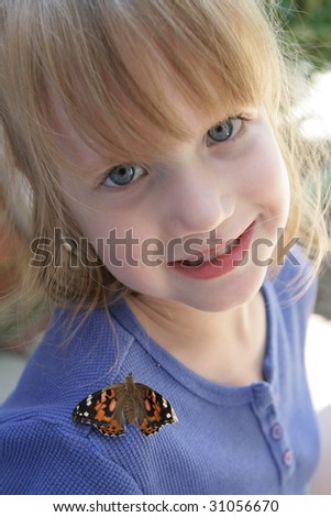 A beautiful child with a butterfly on her shoulder