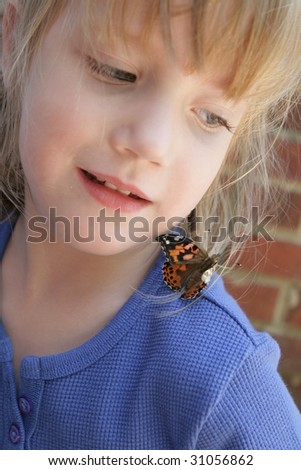 A small girl with a butterfly on her shoulder