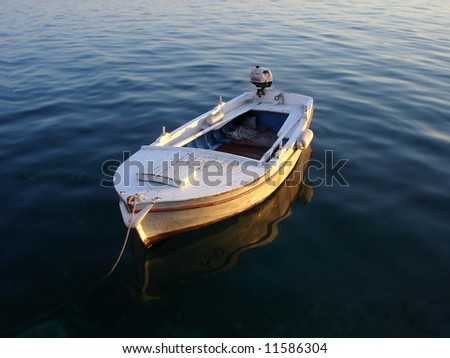 wooden boat anchored on dark calm sea