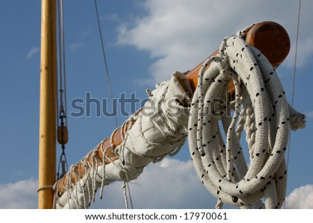 Wooden mast and boom with sail and ropes