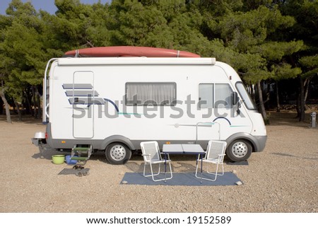 White camper with red kayak on roof