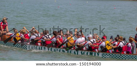 CALGARY, CANADA - AUGUST 11: Dragon Boat team works together in the annual Calgary Dragon Boat Race & Festival on 11 August 2013 at North Glenmore Park in Calgary.