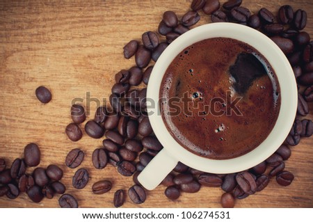 cup of black coffee and coffee beans on a wooden board retro style