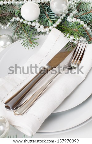 Festive Christmas table setting, table decoration in white, with fir branches, Christmas balls on a white background, isolated