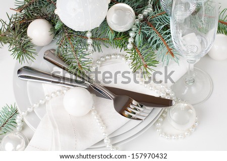 Festive Christmas table setting, table decoration in white, with fir branches, Christmas balls on a white background, isolated