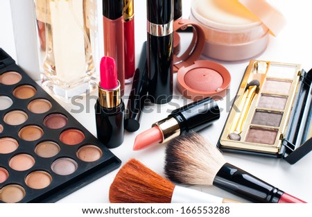 Professional makeup set: eyeshadow palette, lipstick, mascara, blush, powder, make-up brushes and perfume, many cosmetics closeup.