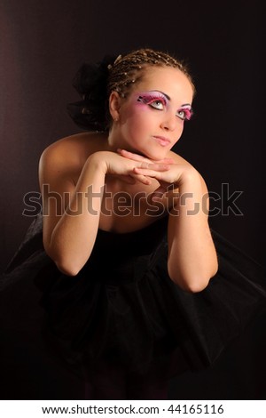 Girl with false eyelashes in black ballet dress