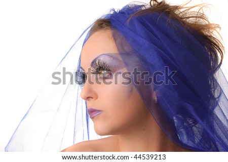 Portrait of a model with an unusual theatrical makeup in a blue headdress