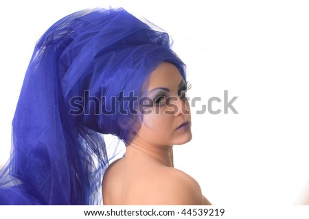Portrait of a model with an unusual theatrical makeup in a blue headdress