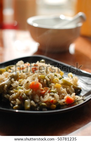 Rice with carrots, corn and peas on a plate