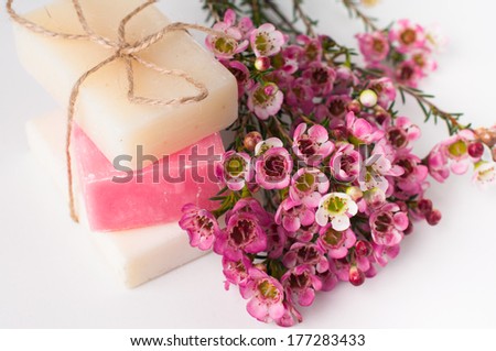 White and pink handmade soap and pink cherry blossoms on a white background, isolated. Gifts and handmade souvenirs.