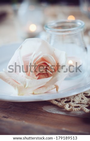 Festive table decoration, vintage table setting with beige rose, candles and antique cutlery