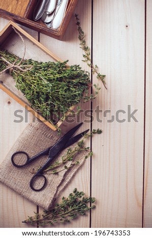 Rustic kitchen still life, dried herbs, old boxes and vintage scissors on a wooden table, home background