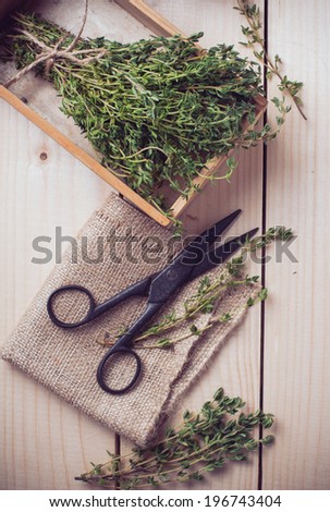 Rustic kitchen still life, dried herbs, old boxes and vintage scissors on a wooden table.