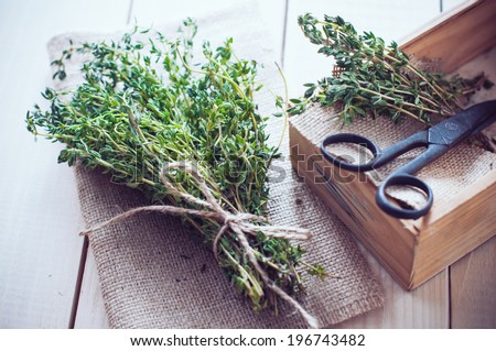 Rustic home kitchen still life, dried herbs, old boxes and vintage scissors on a wooden table.