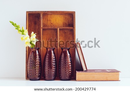 Vintage home decor, three brown glass flower vases, wooden box and old books on a white background.