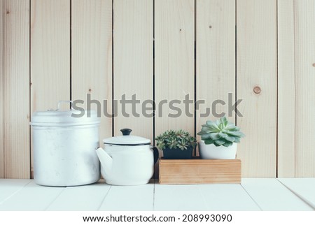 Vintage home arrangement, summer plants and enamelware on a barn wall background, soft pastel colors.