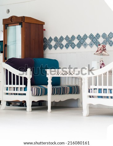 White furniture on the summer house terrace in beige and blue tones, walls with tiles, Moroccan style