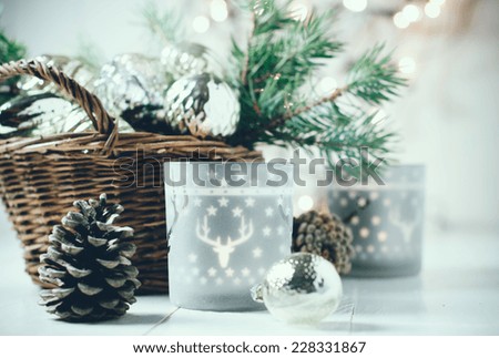 Vintage Christmas decor, old Christmas decorations in a basket, lanterns, garlands and spruce branches on a white table.