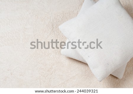 Cozy home, two pillows on beige fluffy carpet on the floor