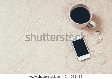Cozy relaxing at home, coffee and player with headphones on the carpet