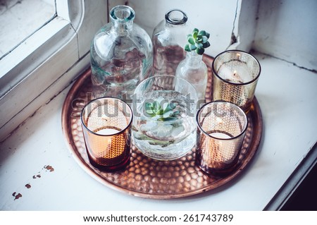 Old bottles, candles on a copper vintage tray, vintage home decor