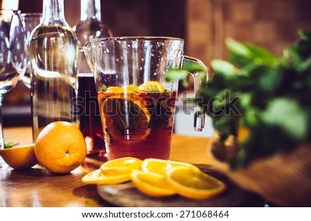 Large jar of sangria with red wine, oranges and ice for home party, home kitchen interior. Homemade food and drinks